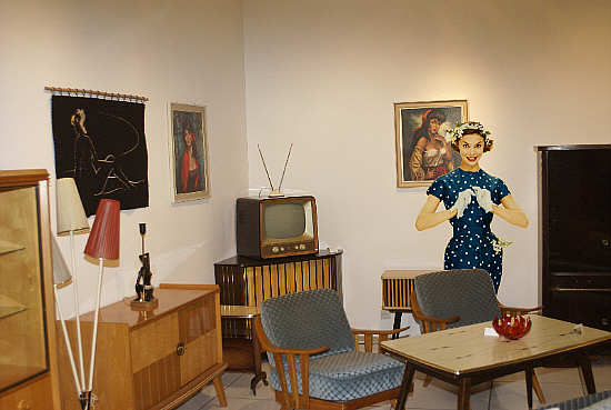 Wohnzimmereinrichtung mit Lackmbeln, montiert mit einem Titelmodell von Burda Moden (1957)