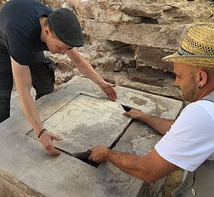 Anhebung der Inschriftenplatte des Grundsteins durch Maxim Kromm und Michael Schrem (von links).