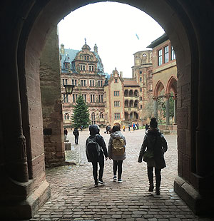 Blick durch den Tordurchgang inden Schlosshof. Die drei jungen Damen sind aus dem selben Haushalt und dürfen deshalb nah beieinander gehen.