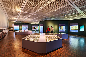 Blick in den größten Ausstellungsraum mit zwei Bodenvitrinen zu den Fundplätzen Thorsberg und Nydam.